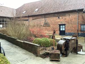 a yard with a brick building and a garden at Gastroatelier in Gooik