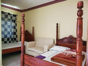 a bedroom with a four poster bed and a couch at Havannah Campsite and Homestay in Fort Portal