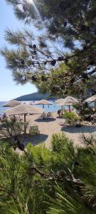 - une plage avec des parasols et des chaises et l'océan dans l'établissement Kuća za odmor Mirozlat, à Saplunara