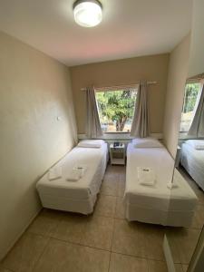 - une chambre avec 2 lits et une fenêtre dans l'établissement POUSADA OASIS DE MINAS, à Carmo do Rio Claro