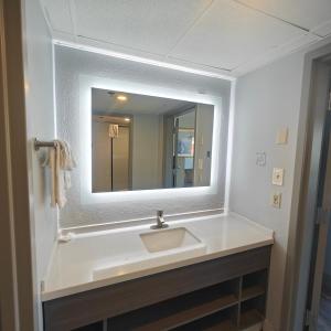 a bathroom with a sink and a mirror at Mountain Vista Inn & Suites - Parkway in Pigeon Forge