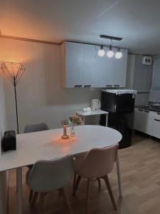 a kitchen with a white table and chairs in a room at Nroo Stay in Seoul