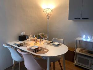 a table with chairs and a white table with wine glasses at Nroo Stay in Seoul