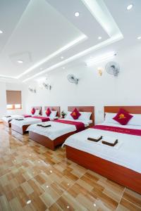 a group of four beds in a room at The Sun Long Hai Hotel in Long Hai