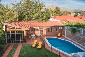 un patio trasero con piscina y una casa en Hostel Falucho en Capilla del Monte