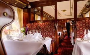a dining car of a train with white tables at Glenlo Abbey Hotel in Galway