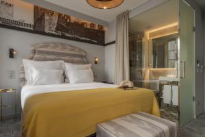 een slaapkamer met een groot bed en een gele deken bij Pousada Alfama in Lissabon