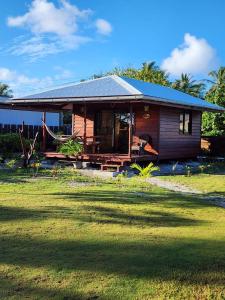 a small house with a lawn in front of it at Bungalow Kahaia Lodge in Avatoru