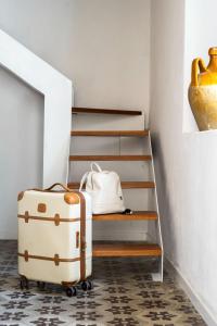una maleta sentada en el suelo junto a una escalera en Iancura - B&B di design a Salina, en Santa Marina Salina