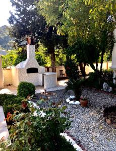 a garden with a bench and a fireplace with trees at Boutique Hotel Akvilla in Sarigerme