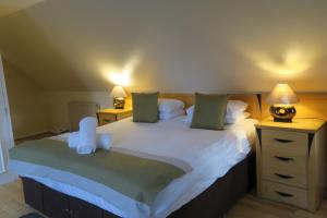 1 dormitorio con 1 cama grande y 2 mesitas de noche en The Inn At Lathones, en St Andrews