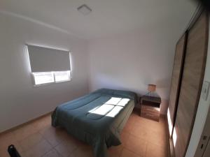 ein kleines Schlafzimmer mit einem Bett und einem Fenster in der Unterkunft La Cañada in Juana Koslay 