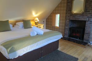 1 dormitorio con 1 cama grande y chimenea en The Inn At Lathones, en St Andrews