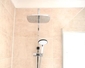 y baño con ducha con cabezal de ducha. en Hermitage, 3 Bed entire House in Loughborough en Loughborough