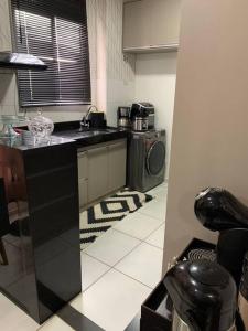 eine Küche mit einer Spüle und einer Waschmaschine in der Unterkunft Um apartamento bem aconchegante! in Palmas
