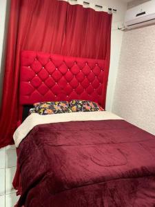 1 cama roja con cabecero rojo en una habitación en Um apartamento bem aconchegante! en Palmas