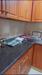 a kitchen with wooden cabinets and a counter top at عجمان in Ajman 