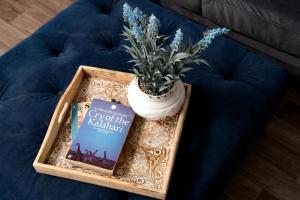 um livro sentado numa mesa ao lado de uma planta com vasos em Dreamwood - Woodland Cottage with Private Hot Tub em Blandford Forum