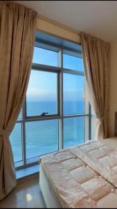 a bedroom with a large window and a bed at عجمان in Ajman 