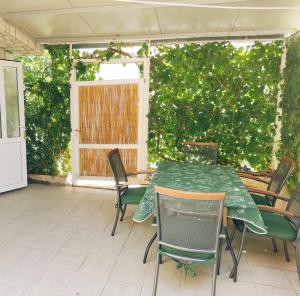 een groene tafel en stoelen op een patio bij Apartments Mimi Omis in Omiš