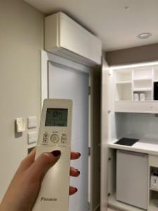 a person holding a remote control in front of an open refrigerator at Hendon Studios in The Hyde