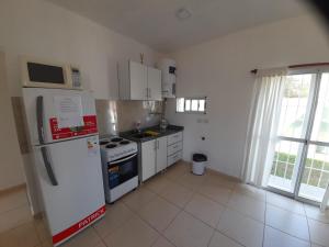 a kitchen with a white refrigerator and a microwave at La Cañada in Juana Koslay 