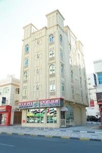 a large building on the corner of a street at Miami Hotel Apartment in Sharjah