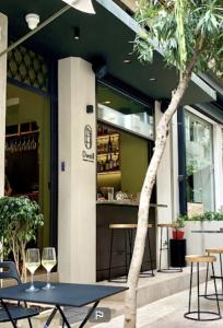 uma mesa com copos de vinho em frente a uma loja em DWELL - Elegant City Stay em Atenas