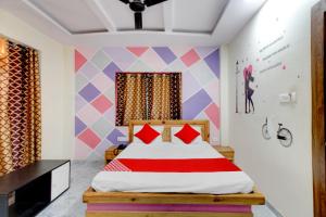 a bedroom with a bed and a colorful wall at Hotel O Holiday Prime in Nagpur
