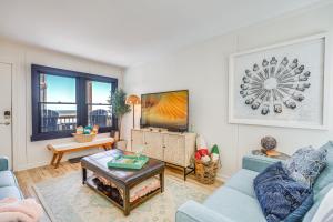 a living room with a blue couch and a table at Kill Devil Hills Condo with Beach Access On-Site! in Kill Devil Hills