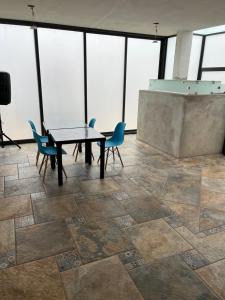 una mesa y sillas en una habitación con ventanas en Casa Tequila Club Taraza1, en Arandas