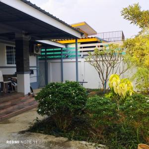 une maison avec une terrasse couverte dans l'établissement Bann Sukjai, à Kanchanaburi