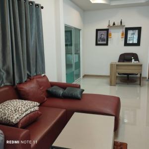 a living room with a brown leather couch at Bann Sukjai in Kanchanaburi