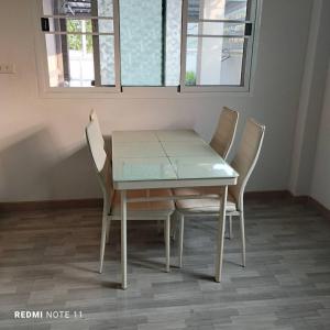 a dining room table with four chairs around it at Bann Sukjai in Kanchanaburi