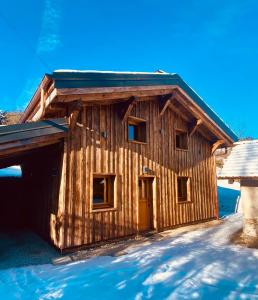 a log cabin with a yellow door in the snow at Chalet du Bonheur in Saint-Gervais-les-Bains
