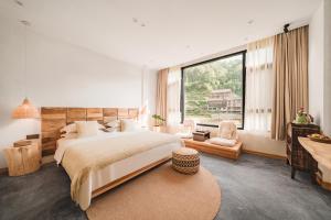 1 dormitorio con cama grande y ventana grande en 肇兴溪舍山堂 Creekside Inn en Liping