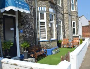 a building with a bench on the grass outside at Coastal One Bedroom Apartment Free Parking in Great Yarmouth