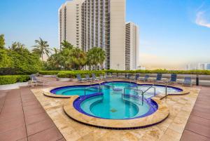 a swimming pool with chairs and a building at Blooming Sun Direct Ocean View in Miami