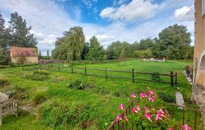 a wooden fence in a field with pink flowers at Gorgeous Home In commoy With Heated Swimming Pool in Écommoy