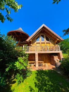 um grande chalé de madeira com uma grande varanda e uma casa em Kuća za odmor “Mita” em Sveti Martin na Muri