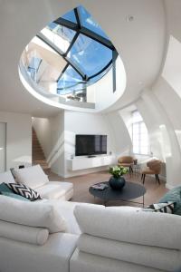 a living room with a white couch and a large window at Triplex penthouse in the city center in Brussels