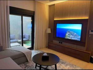 a hotel room with a television and a living room at وحدة الملقا لاقزجري in Riyadh