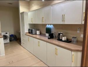 a kitchen with white cabinets and a counter top at شقة الملقا الفندقية in Riyadh
