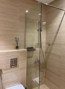 a shower with a glass door in a bathroom at شقة الملقا الفندقية in Riyadh