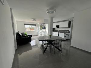 een woonkamer met een tafel en een keuken bij JeLe Guest Room in Playa del Inglés