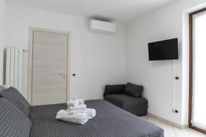 - une chambre avec un lit, une chaise et une télévision dans l'établissement Relax house Baveno, à Baveno