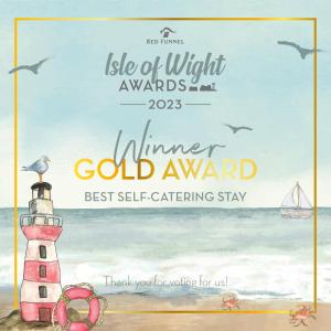 a poster for a winter gold award with a lighthouse on the beach at East Street Beach House - luxury living by the sea in Ryde