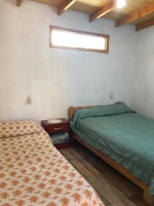 a bedroom with two beds and a window in it at Franlu in Lago Puelo