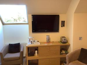 a living room with a flat screen tv on the wall at Heatherbrae Guest House in Kyle of Lochalsh