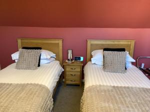 two beds sitting next to each other in a room at Heatherbrae Guest House in Kyle of Lochalsh